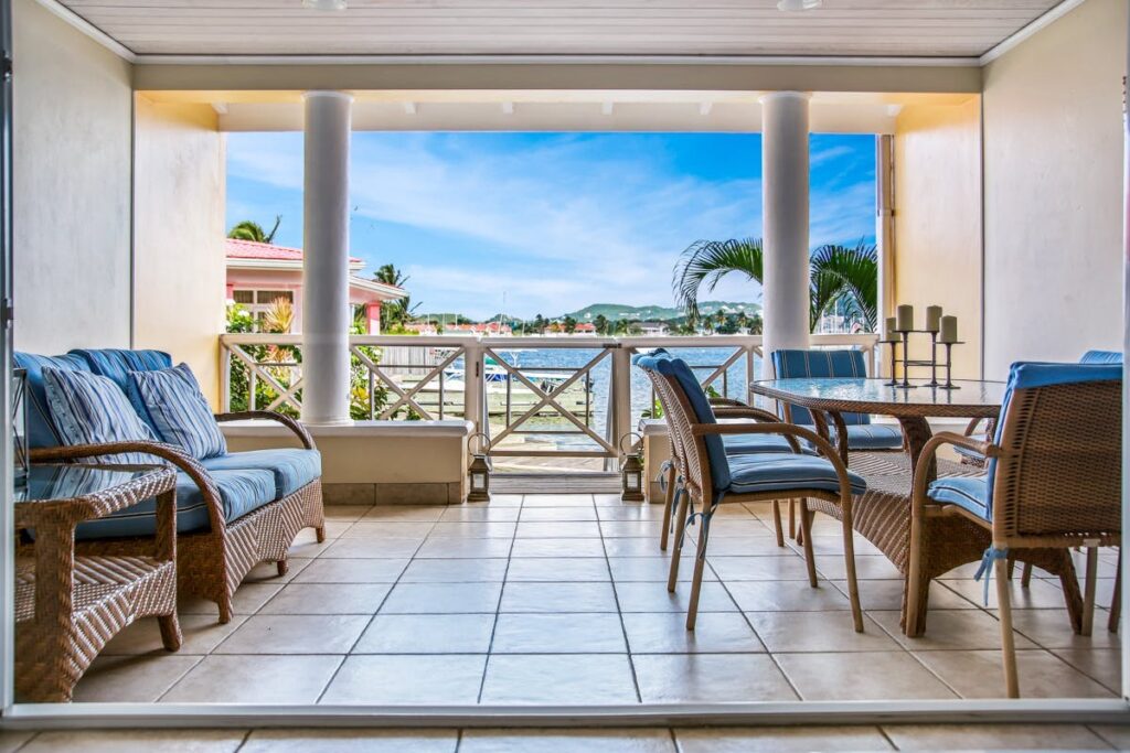 Blue-themed wooden dining set and sofa near the terrace at the Bay Breeze Retreat villa