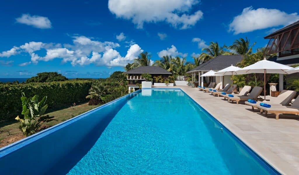 Infinity pool with sun loungers at the Caribbean Queen villa, overlooking the Caribbean Sea