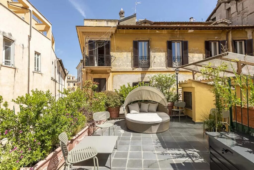 Rooftop terrace surrounded by ochre facades at the Divino Amore villa