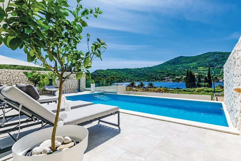 Infinity pool with a view of lush green hills at the Dubrovnik Dream villa