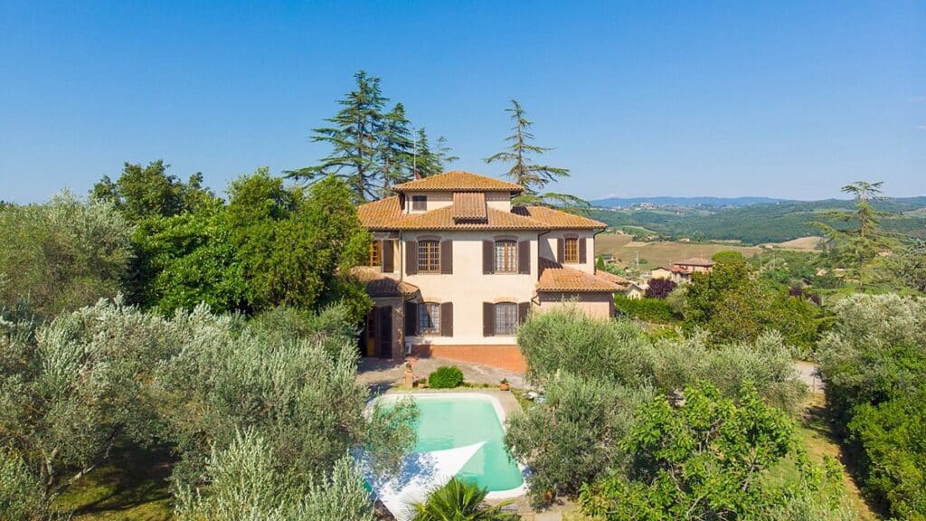 Outdoor view of the Into the Olive Grove villa with a pool surrounded by woods