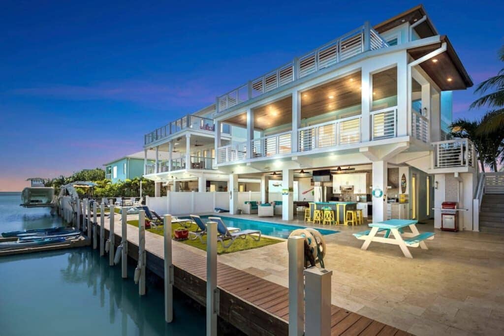 On the Ocean's Shore waterfront villa with a dock and a pool with loungers