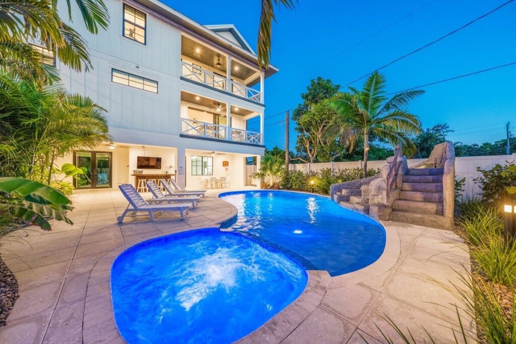 Pool with loungers and a waterslide near the patio area of the Paradise Cove Retreat villa