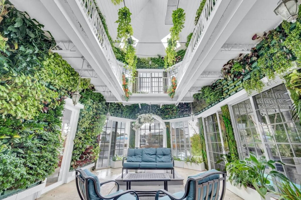 Living room of the Sunshine Magic villa surrounded by a two-level botanical greenhouse