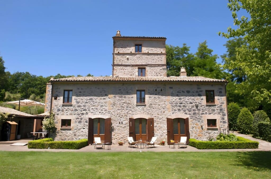 Building view of The Olive Way villa with outdoor tables and chairs