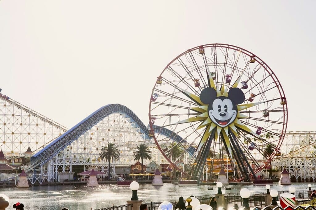 Mickey Mouse Ferris wheel across the river with a roller coaster in the background