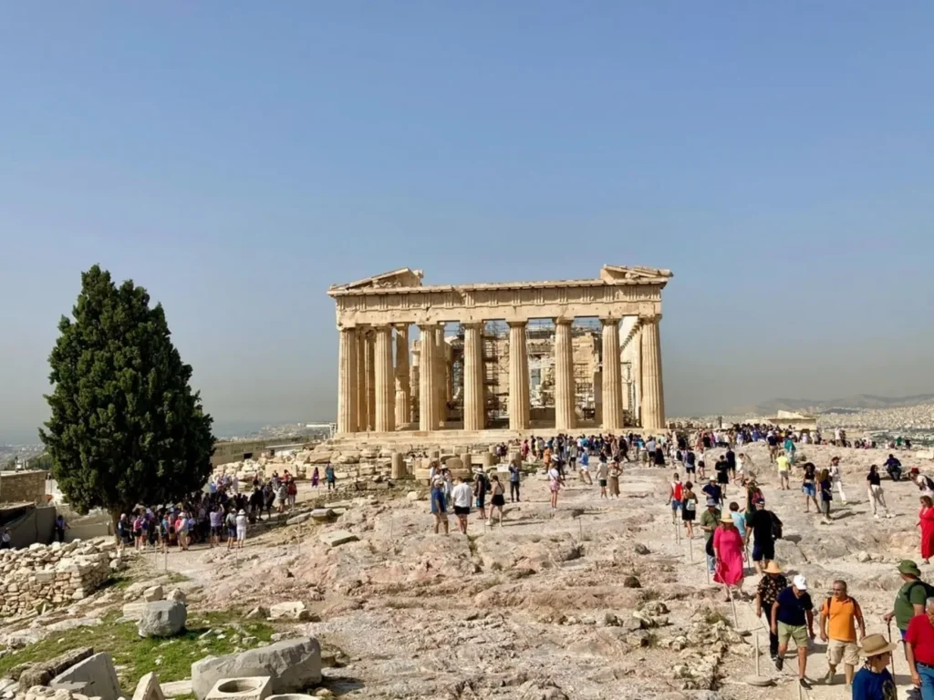 Tourists walking around the Parthenon at the Acropolis in Athens on a clear day during a family reunion trip