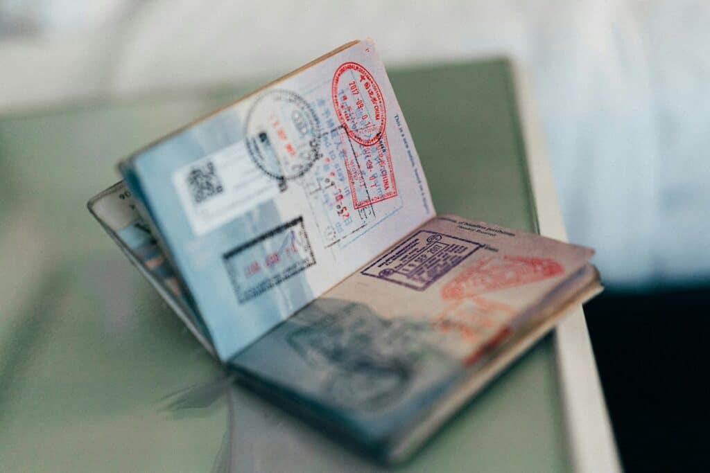 Open passport showing stamped pages on a glass table