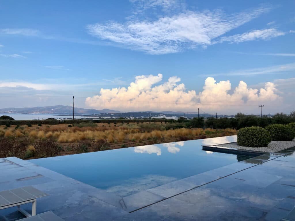 Infinity pool overlooking a scenic landscape with distant mountains and the sea.