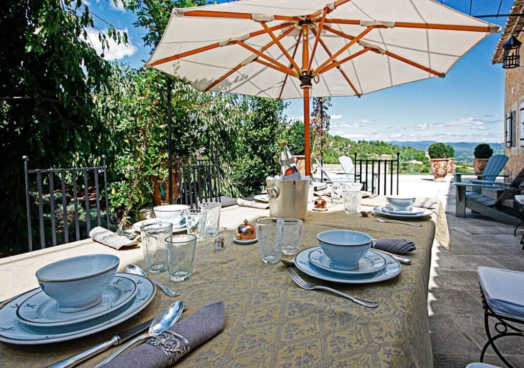 Outdoor dining table with umbrella at a luxury villa in Provence, home base for a milestone 40th wedding anniversary.