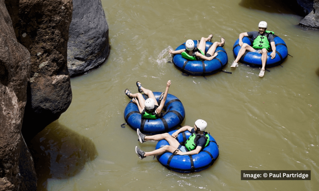 Family members tubing down a river together during a family reunion vacation.