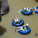Family members tubing down a river together during a family reunion vacation.