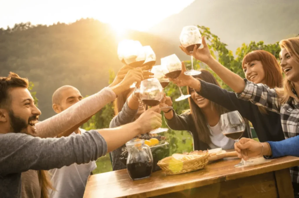 Friends celebrating a reunion, toasting with wine glasses at a villa at sunset