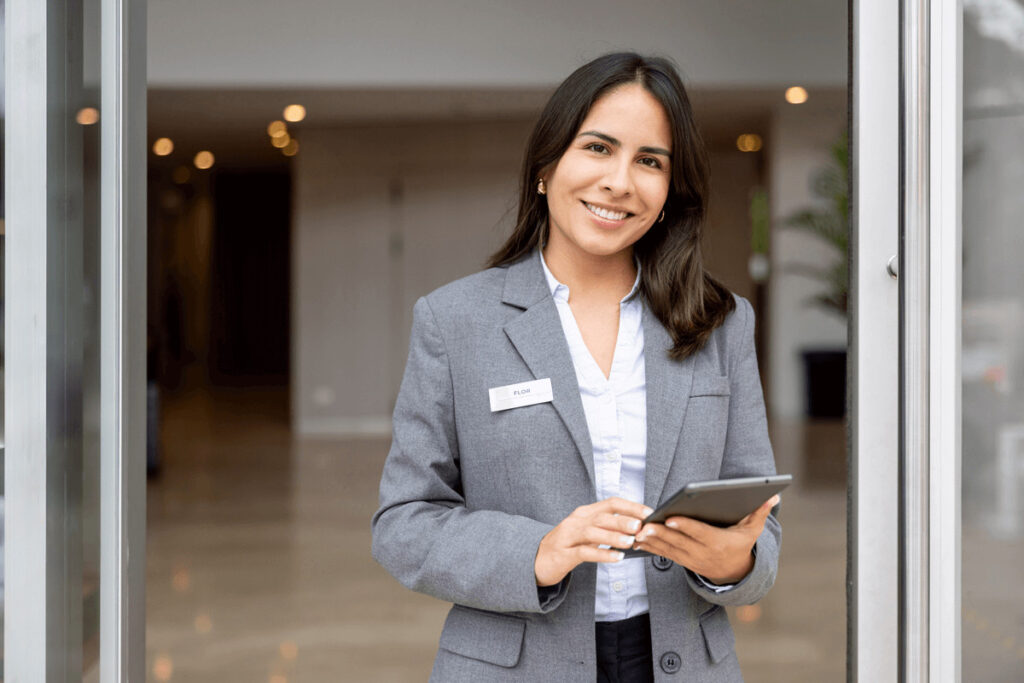 Smiling villa concierge holding a tablet representing personalized service for luxury villa guests on a celebration vacation.