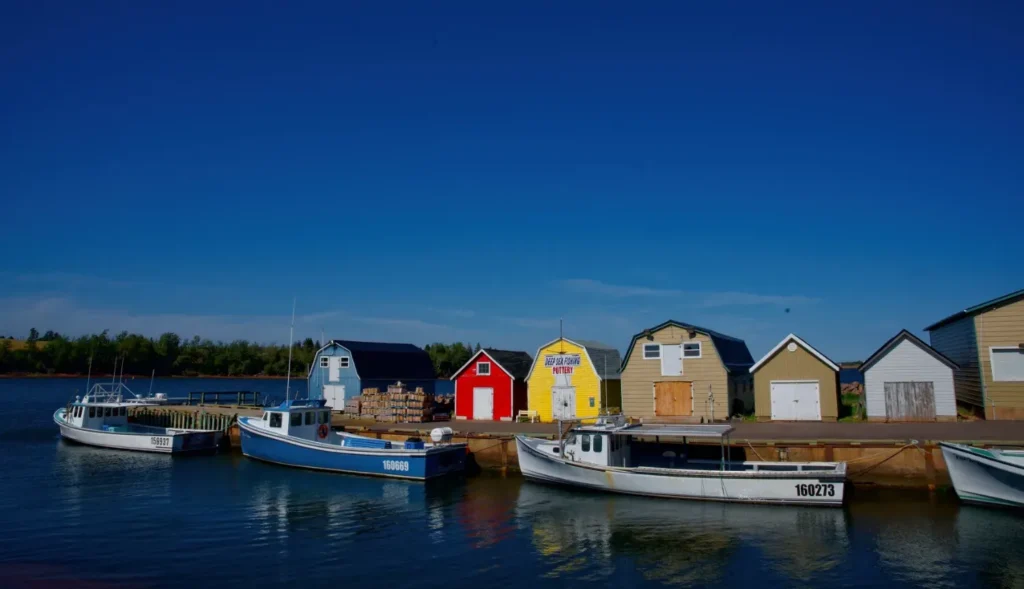 A tranquil scene of fishing boats docked in front of colorful buildings in prince edward island, canada.