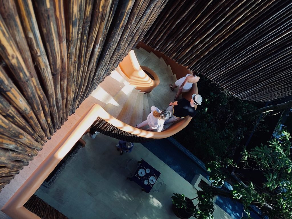 Overhead view of a family descending a curved staircase towards a pool in costa rica.