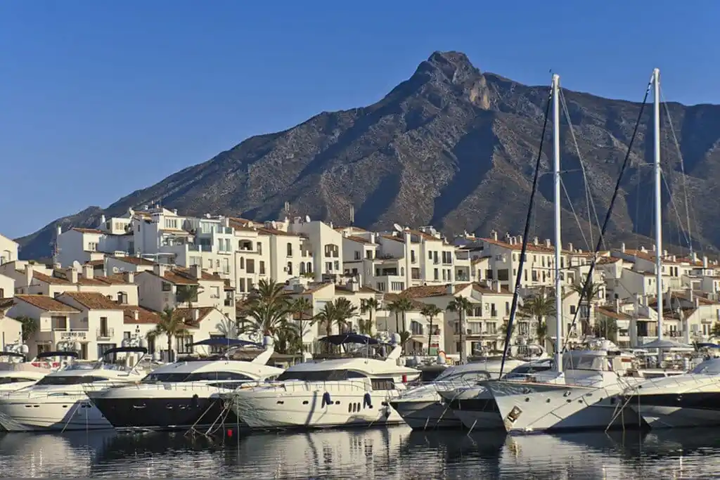 Yachts docked in Puerto Banús, Marbella, Spain, with a backdrop of buildings
