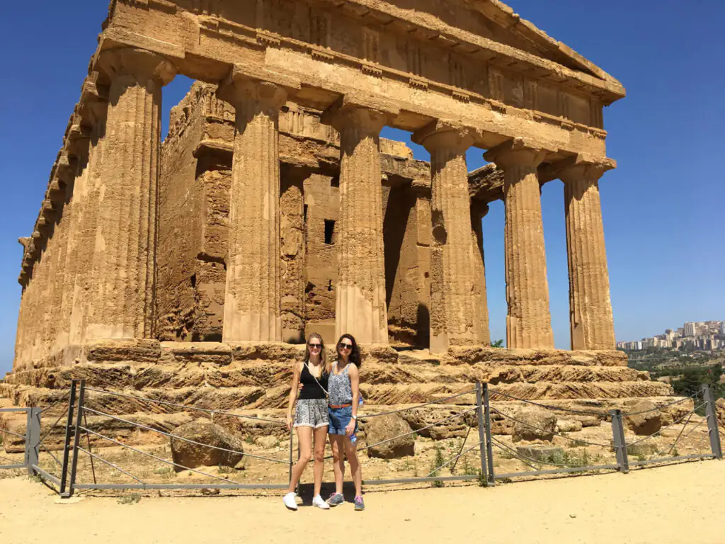 Two women posing for photos at The Valley of the Temples in Agrigento during a family heritage trip in Sicily.