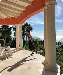 Woman exercising on a villa pavilion in turks and caicos during a multi-generational family trip.