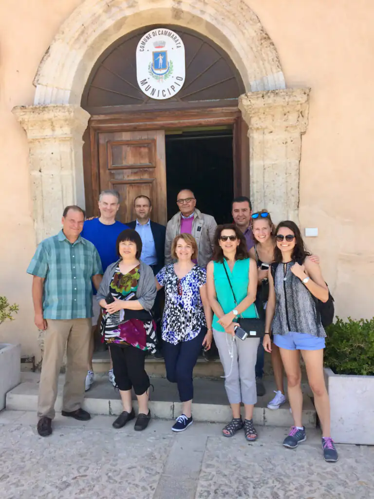 Three generations of Americans meet the Mayor of Cammarata in front of the town hall during a family heritage trip in Sicily.